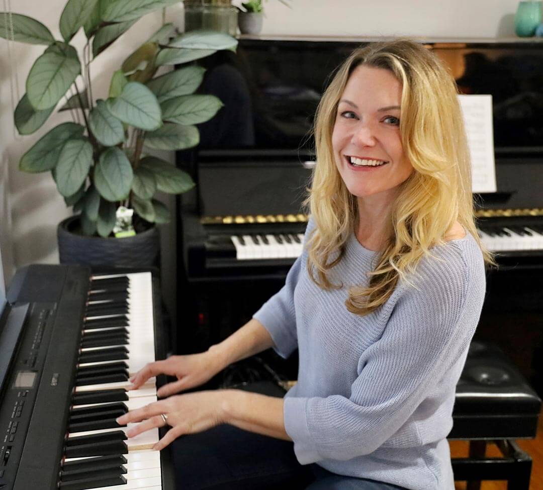 Michelle Orpe, an online piano teacher, playing her piano.